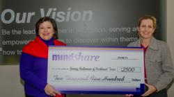 Mentoring Minds employee, Connie Moore, presents MindSHARE award to Amy Baskin, Executive Director at Young Audiences of Northeast Texas